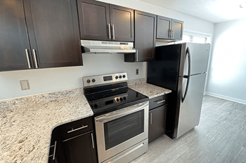 Tartan Place kitchen in Fayetteville with electric range and self-cleaning oven as well as refrigerator